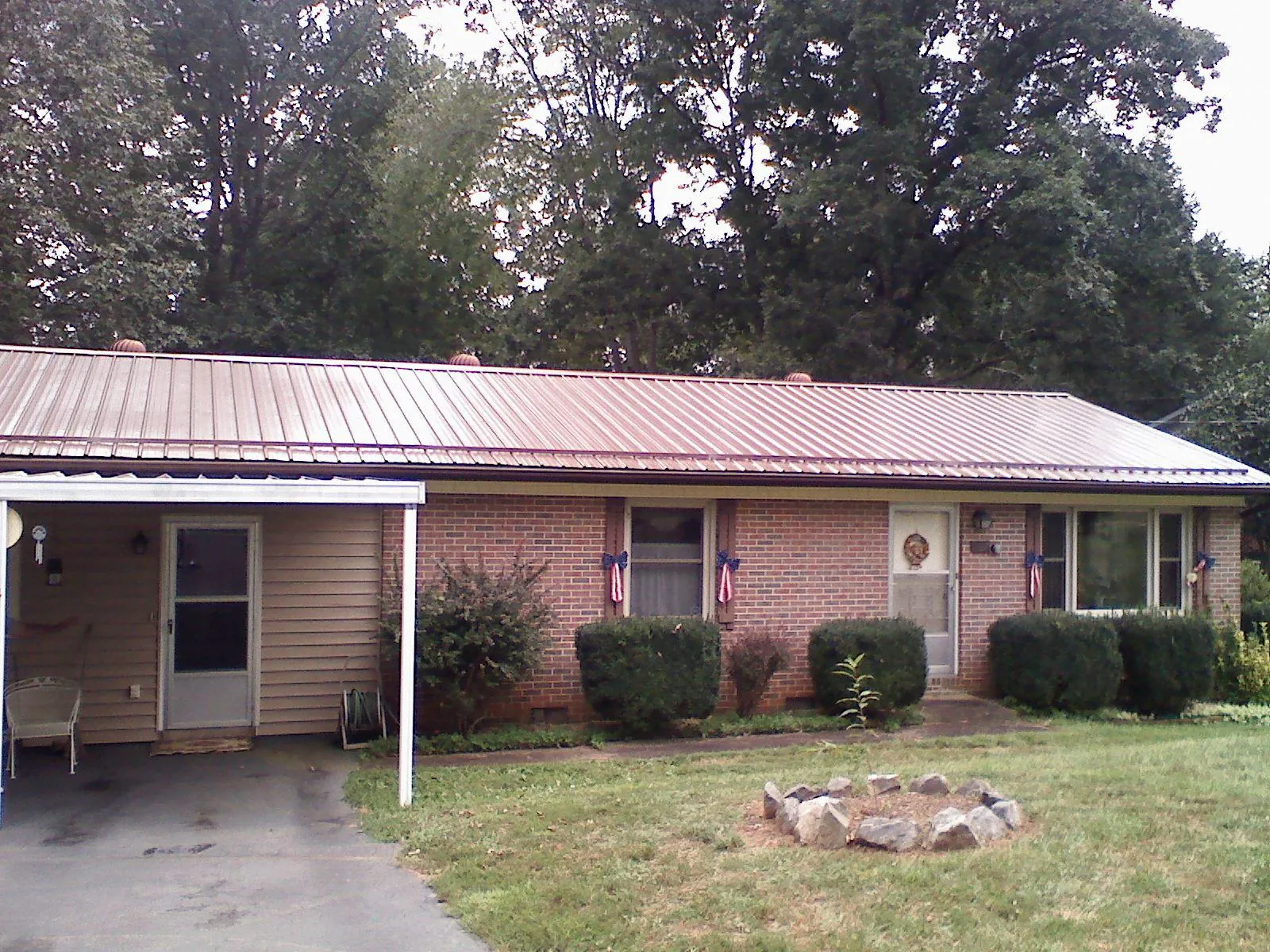 Bronze metal roof and carport on a brick ranch home — Roof Repair work by our crew in Manning